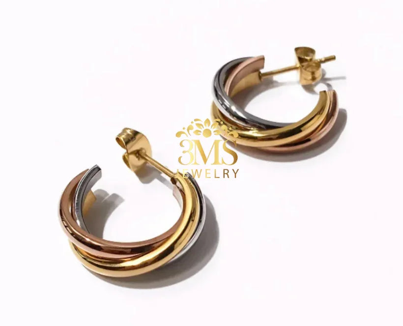 Pair of tri-color hoop earrings in gold, silver, and rose gold on white background