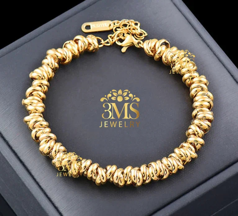 Gold twisted bead bracelet from 3MS Jewelry displayed on black box