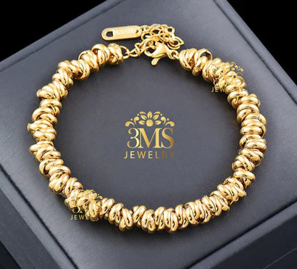 Gold twisted bead bracelet from 3MS Jewelry displayed on black box