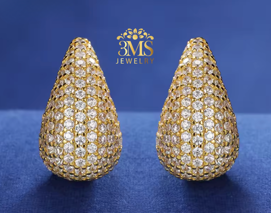 18K vermeil gold moissanite diamond Teardrop-shaped gold and diamond earrings on a blue background with BMS Jewelry logo.ani
