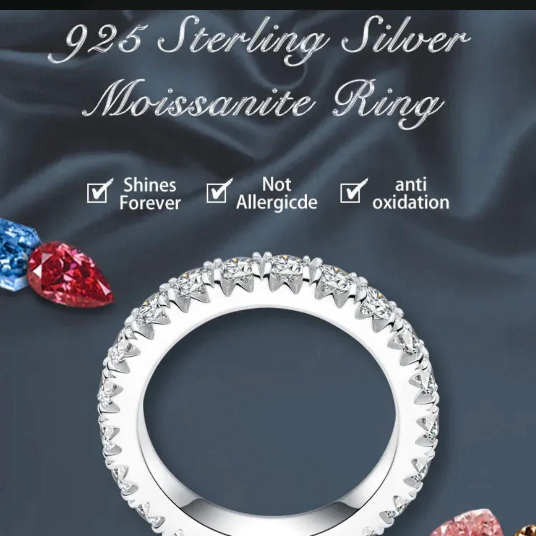 925 sterling silver moissanite ring with sparkling round stones on dark fabric background