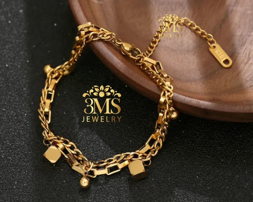 "18K gold chain bracelet with charms in titanium steel with gold vermeil—front zoom view"