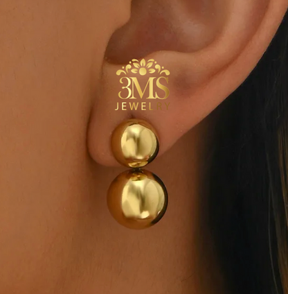 "18K gold two-beaded drop earrings in titanium steel with gold vermeil—on-ear wearing view"