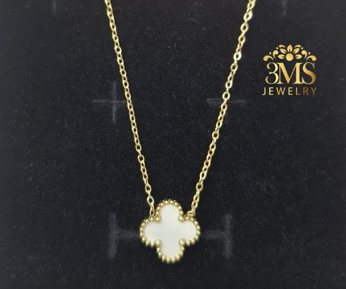 Gold chain necklace with white clover-shaped pendant on black velvet background by 3MS Jewelry