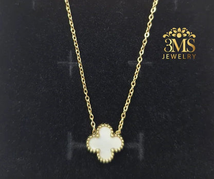 Gold chain necklace with white clover-shaped pendant on black velvet background by 3MS Jewelry