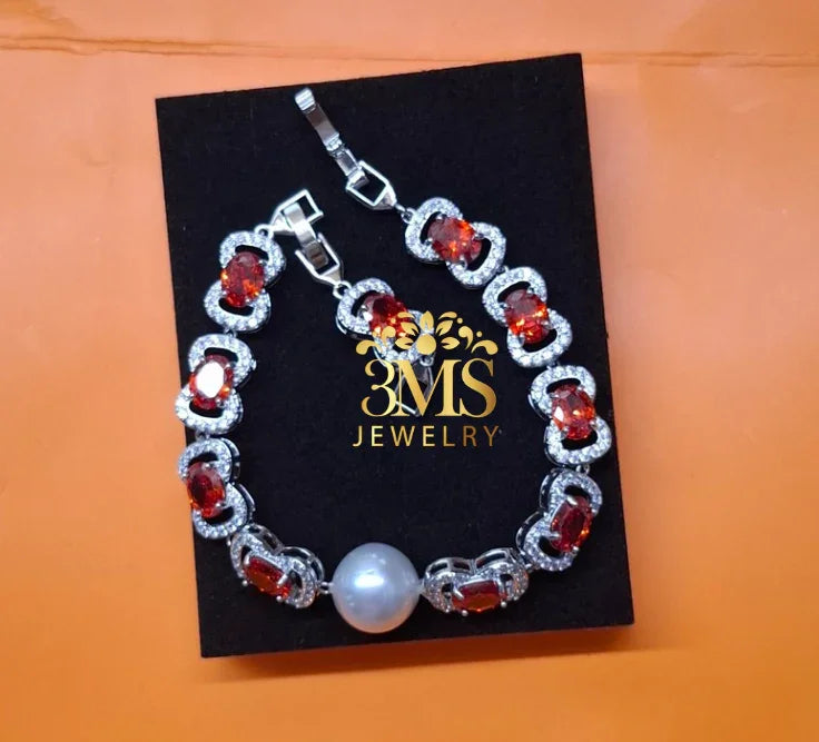 silver bracelet with red garnet gemstones and a single large pearl on black 3MS Jewelry card