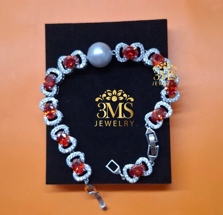 3MS Jewelry garnet bracelet with red gemstones, silver-tone setting, and single large pearl on black card