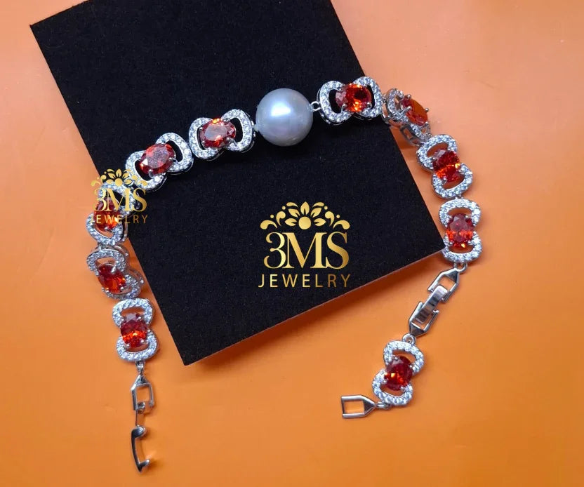 Silver bracelet with red garnet stones, white pearl, and diamond accents on black 3MS Jewelry box