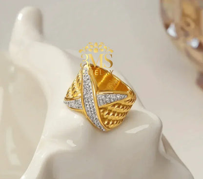 Elegant gold ring with diamond-studded twisted design displayed on white ceramic stand