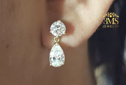 "Lab diamond round brilliant-cut and pear-cut drop earrings in 14K yellow gold on wearing-zoom view."