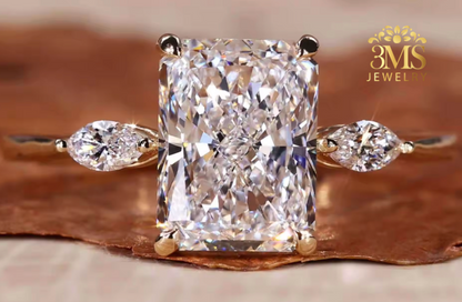 "Lab diamond radiant-cut engagement ring in three-stone design and 14K yellow gold settings—a close-up view."