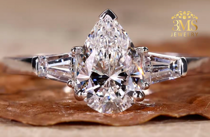"Lab diamond pear-cut in a three-stone design engagement ring set in 14K white gold—front close-up view."