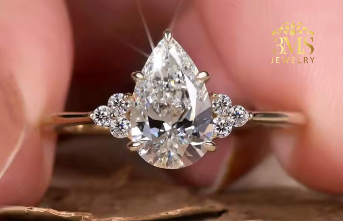 "Lab diamond pear-cut on a three-stone design with a brilliant 3-side-stone engagement ring set in 14K white gold—front close-up view."