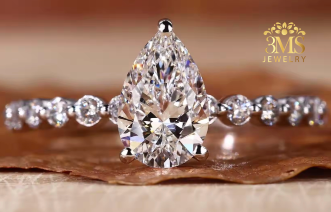 "Lab diamond pear-cut in pavement design engagement ring set in 14K white gold—front close-up view."