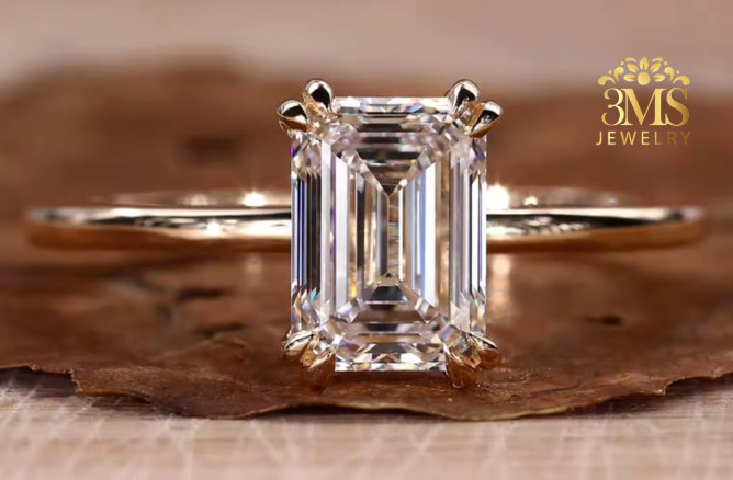 "Lab diamond emerald-cut engagement ring in solitaire design and 14K yellow gold settings—a close-up view."