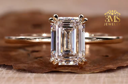 "Lab diamond emerald-cut engagement ring in solitaire design and 14K yellow gold settings—a close-up view."