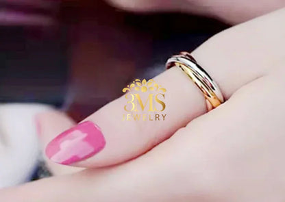 Close-up of a hand with pink nail polish wearing a two-tone gold and silver love ring