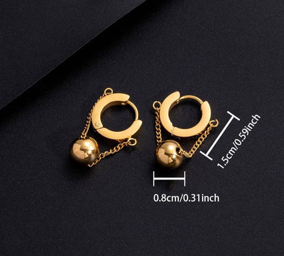 Gold hoop earrings with dangling gold ball charms on black background with size dimensions
