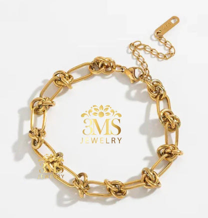 Gold chain bracelet with knotted links and lobster clasp on white background