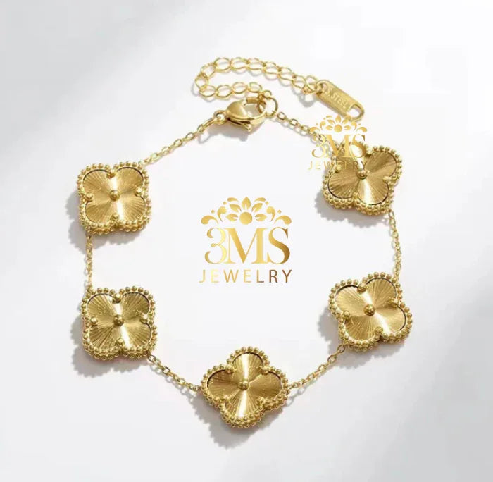 Gold bracelet with five textured flower-shaped charms and adjustable chain clasp on white background