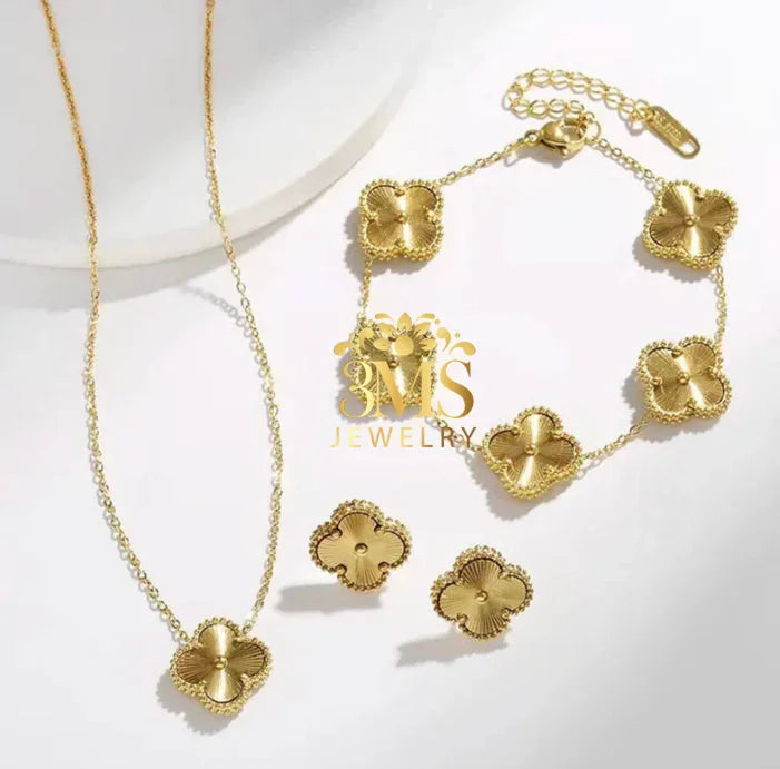Gold flower-shaped jewelry set including necklace, bracelet, and stud earrings on white background