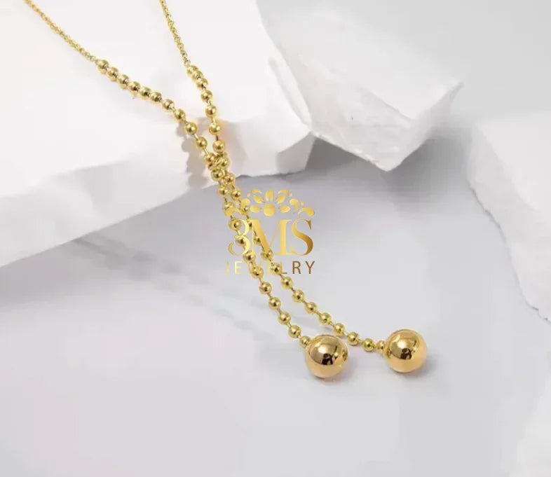 "18K gold two-beaded pendant necklace in titanium steel with gold vermeil—side view"