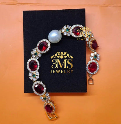 Luxury bracelet with oval red ruby stones, diamonds, emerald accents, and a single pearl on black 3MS Jewelry box