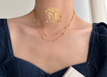 "18K gold 2-layer bead necklace in titanium steel with gold vermeil—on wearing front length view"