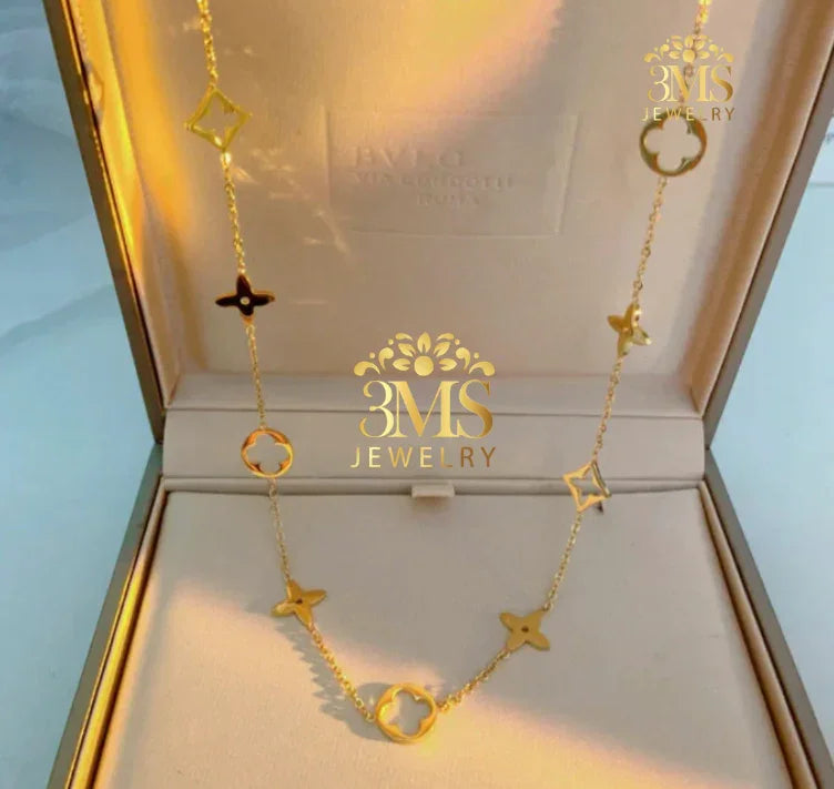 Gold floral and geometric pendant necklace displayed in beige jewelry box with 3MS Jewelry logo