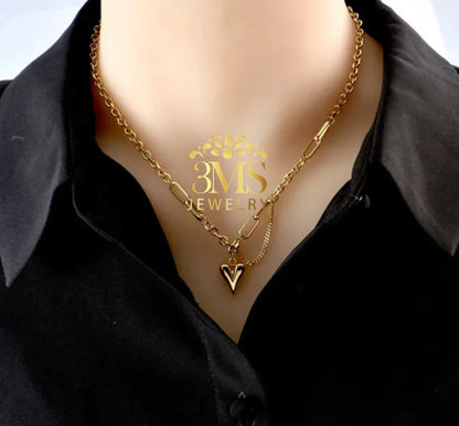 Gold chain necklace with heart pendant worn over black collared shirt by 3MS Jewelry
