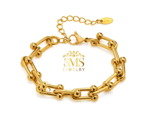 Gold link bracelet with spherical accents and adjustable chain clasp on white background