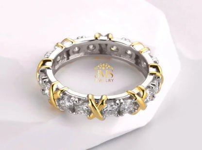 Elegant silver and gold ring with sparkling diamonds in a cross pattern on white background