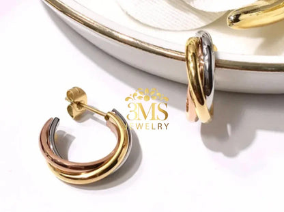 Tri-color hoop earrings in gold, silver, and rose gold on white background with jewelry dish